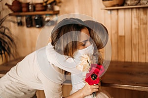 Mom and daughter hugging in masks. Family quarantined. Mother`s day at home