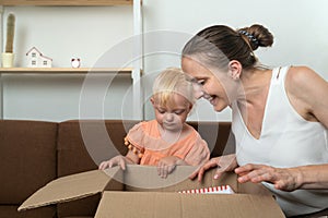 Mom and daughter look into a large cardboard box. Package with gift