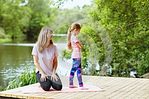 Mom and daughter on morning exercises in the park. The concept of reluctance to train