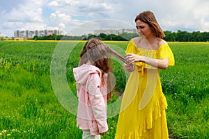 Mom and daughter in nature outdoors lifestyle. Maternal care concept