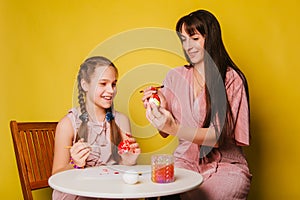 Mom and daughter paint eggs for Easter. A believing woman and a child girl preparing for a religious holiday