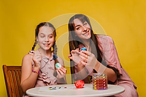 Mom and daughter paint eggs for Easter. A believing woman and a child girl preparing for a religious holiday