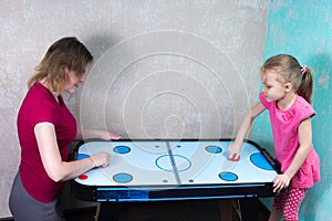 Mom and daughter playing air hockey