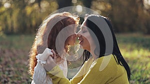 Mom and daughter playing in autumn park, They eating, laughing and smiling. slow-motion