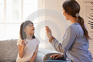 Mom and daughter practice sign language at home
