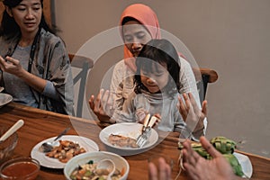 Mom and daughter pray before eating