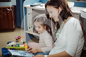 Mom and daughter reading a very interesting book considered