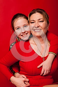 Mom and daughter in red dress cuddle family