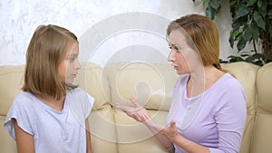 Mom and daughter relationship concept. Mother and teenage daughter swearing while sitting on the sofa in the living room