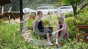 Mom and daughter are resting in the park in the recreation area. The family plays games on the phone