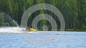 Mom and daughter ride along the river on a personal watercraft.