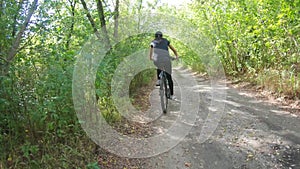 Mom and daughter ride bicycles in the forest in summer.