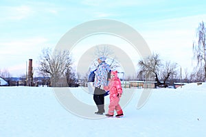 Mom and daughter ride a tubing in winter.