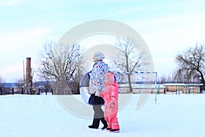 Mom and daughter ride a tubing in winter.