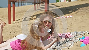 Mom and daughter on the river bank eat ice cream. Outdoor recreation