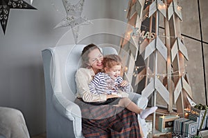 Mom and daughter sitting in a chair in a modern living room