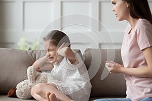 Naughty little daughter close her ears not listen mothers rebuke photo