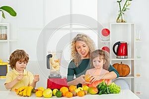 Mom daughter and son prepare a smoothie in the kitchen. Happy loving family. Vegan nutrition and a healthy lifestyle.