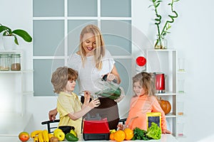 Mom daughter and son prepare a smoothie in the kitchen. Have fun and play with vegetables. Healthy diet and lifestyle