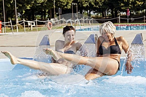 Mom and daughter while spraying water in a whirlpool tub