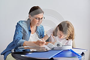 Mom and daughter student learning school lessons together at home