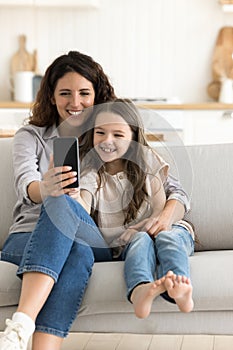 Mom and daughter take selfie photos on mobile phone camera