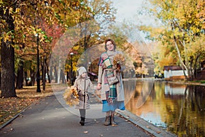 Mom and daughter and walk in the autumn Park near the lake