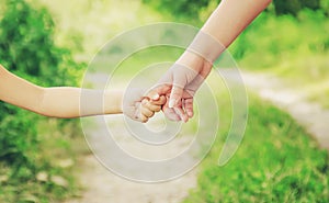 Mom and daughter are walking along the road holding hands