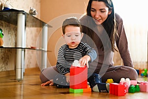 Mom develops her child with toys. The future builder. Boy and mom play with a toy