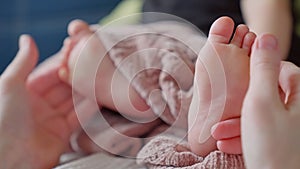 Mom doctor gives a foot massage to her baby. happy family kid baby concept. Children massage: care and care of the