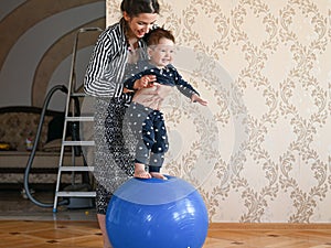 Mom is doing exercises for the baby. Baby and mom develop body motility