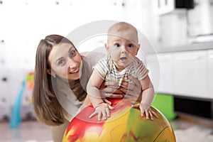 Mom doing exercises on a fit ball with baby.