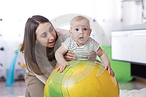 Mom doing exercises on a fit ball with baby.