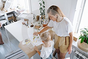 Mom draws with her baby at the table in the house