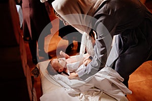 Mom dress their child on a table in the Church. the ordinance of baptism.