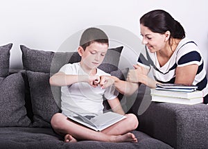 Mom encourages his son for reading a book. photo