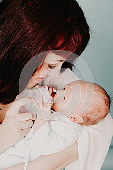 Mom is feeding the baby milk from a bottle