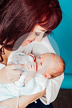 Mom is feeding the baby milk from a bottle