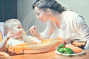 Mom feeds the baby soup. Healthy and natural baby food