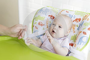 Mom feeds the baby with a spoon