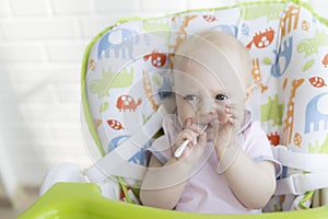 Mom feeds the baby with a spoon