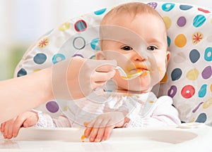 Mom feeds funny baby from spoon