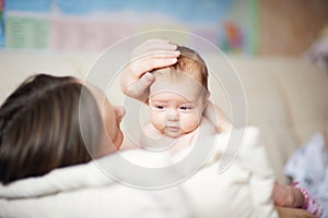 Mom gently stroking the babys head