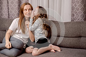 A mom and a girl share secrets. Trusting relationships between parents and children