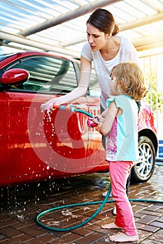 Mom, girl and washing car with teaching or learning for child development, growth and childhood memories. Parent, kid