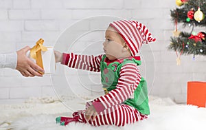 Mom giving Christmas gift to cute baby elf