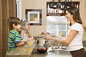 Mom giving kids breakfast.