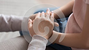 Mom giving support trust to little daughter holding hands, closeup photo