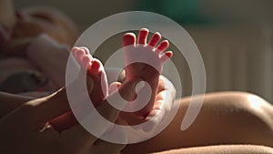 Mom hands foot massage newborn baby