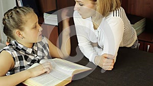 Mom helping her daughter do homework. schoolgirl makes lessons